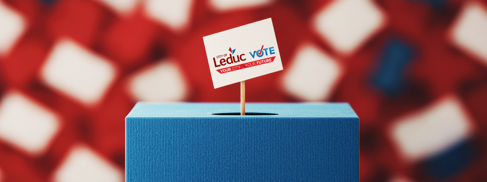 A small sign with "Leduc Vote" is stuck in a blue box, with a blurred red, white, and blue background.